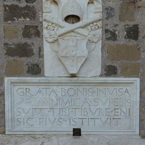 La scritta ammonitrice che compare sul portone d'ingresso alla Rocca Pia, insieme allo stemma del papa Pio II Piccolomini